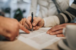 Close up of unrecognizable person signing a legal document.